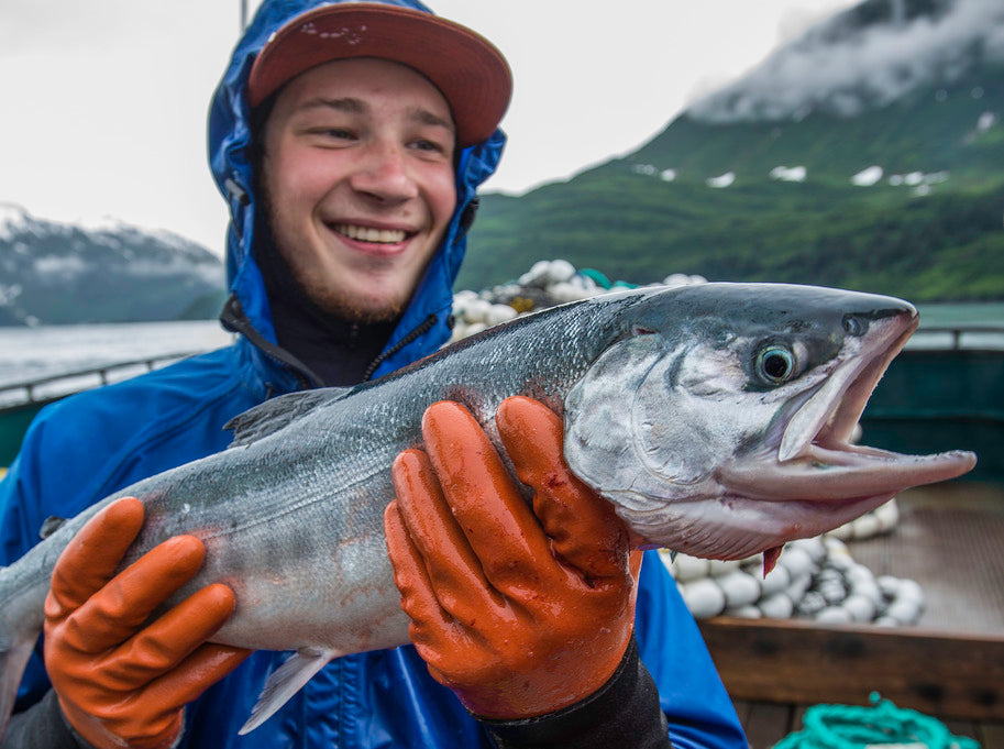 close up of fishermen holding salmon