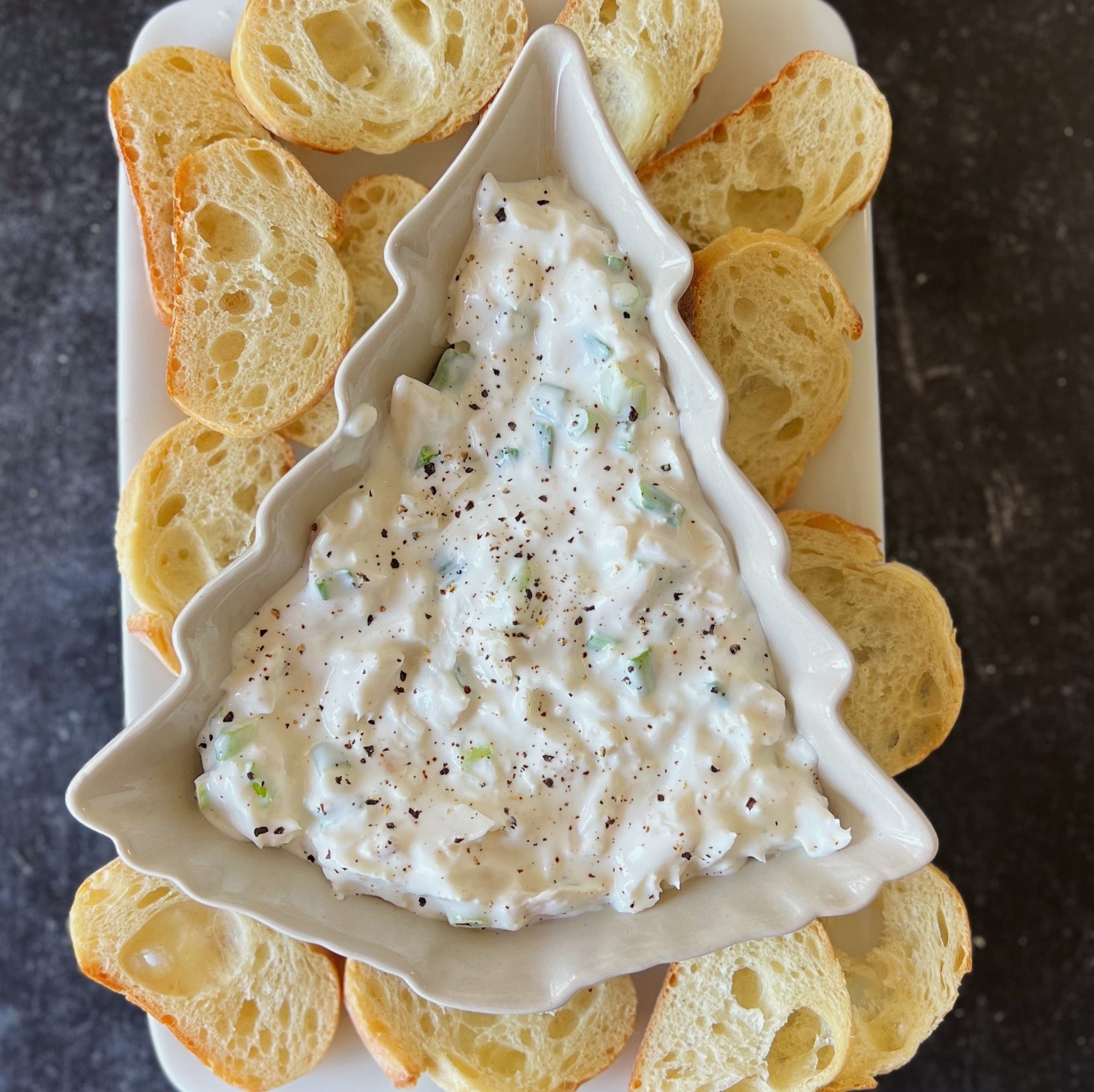 Delicious holiday halibut dip served in a festive dish, garnished with fresh herbs and surrounded by crackers, perfect for holiday celebrations and Christmas dinner ideas.