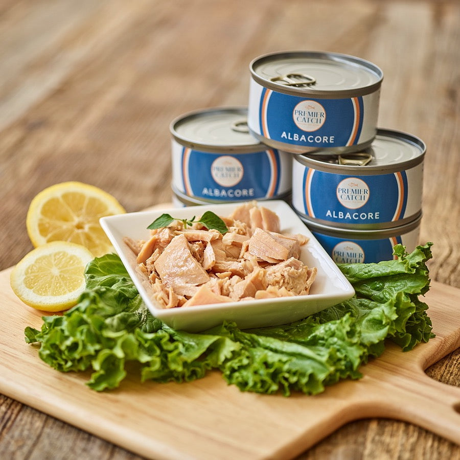 cans of premier catch albacore with one can of tuna displayed in a dish