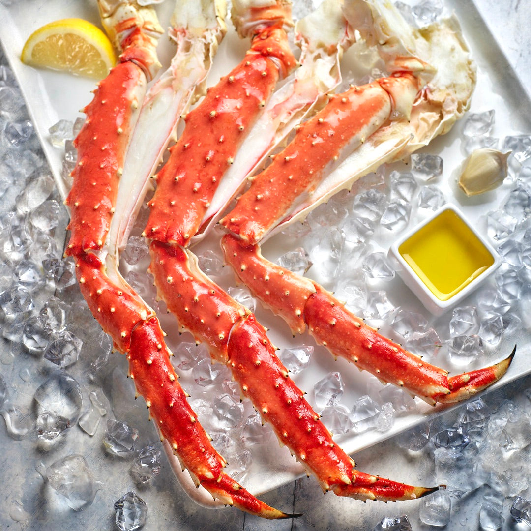 Jumbo Alaskan Red King Crab Legs on a bed of ice with butter and lemon.