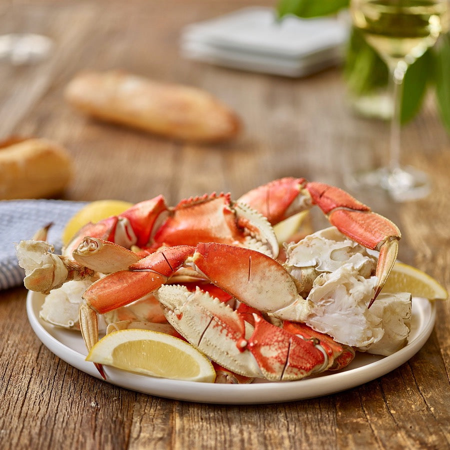 dungeness crab legs on plate with lemon wedges