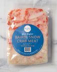 Packaged wild Alaskan Bairdi Snow Crab Meat on a marble background