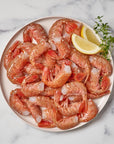 Wild Alaskan spot prawns served on a plate with lemon wedges
