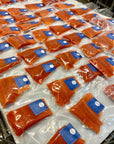 Individually vacuum packed portions of wild sockeye salmon on a white freezing tray.