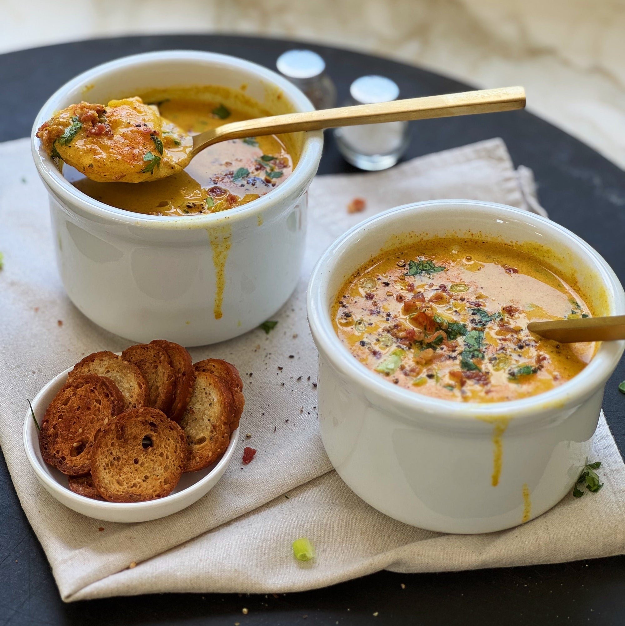 delicious bowls of cajun shrimp and corn bisque with croutons on the side