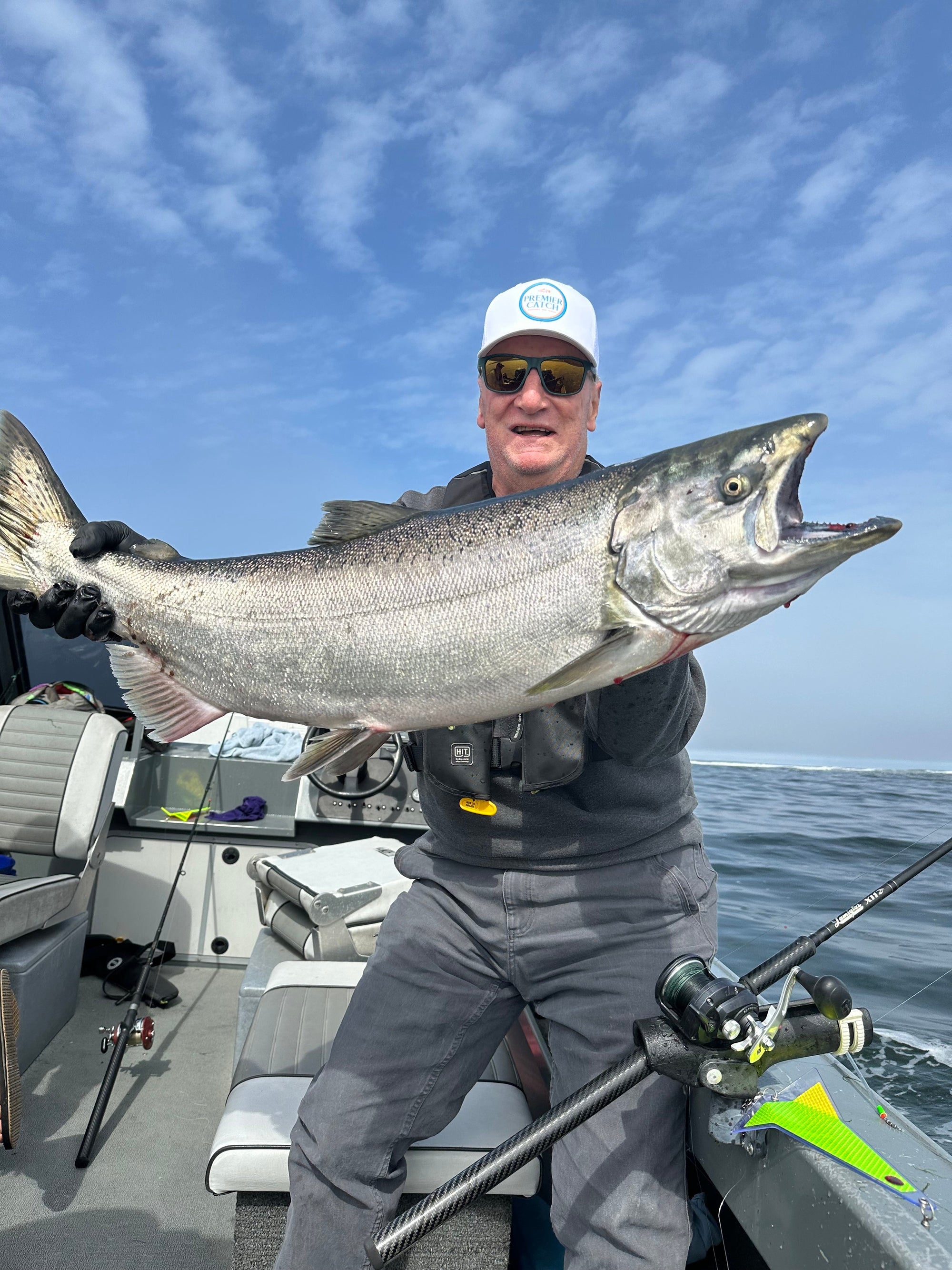 dad catching a giant salmon wearing a premier catch hat