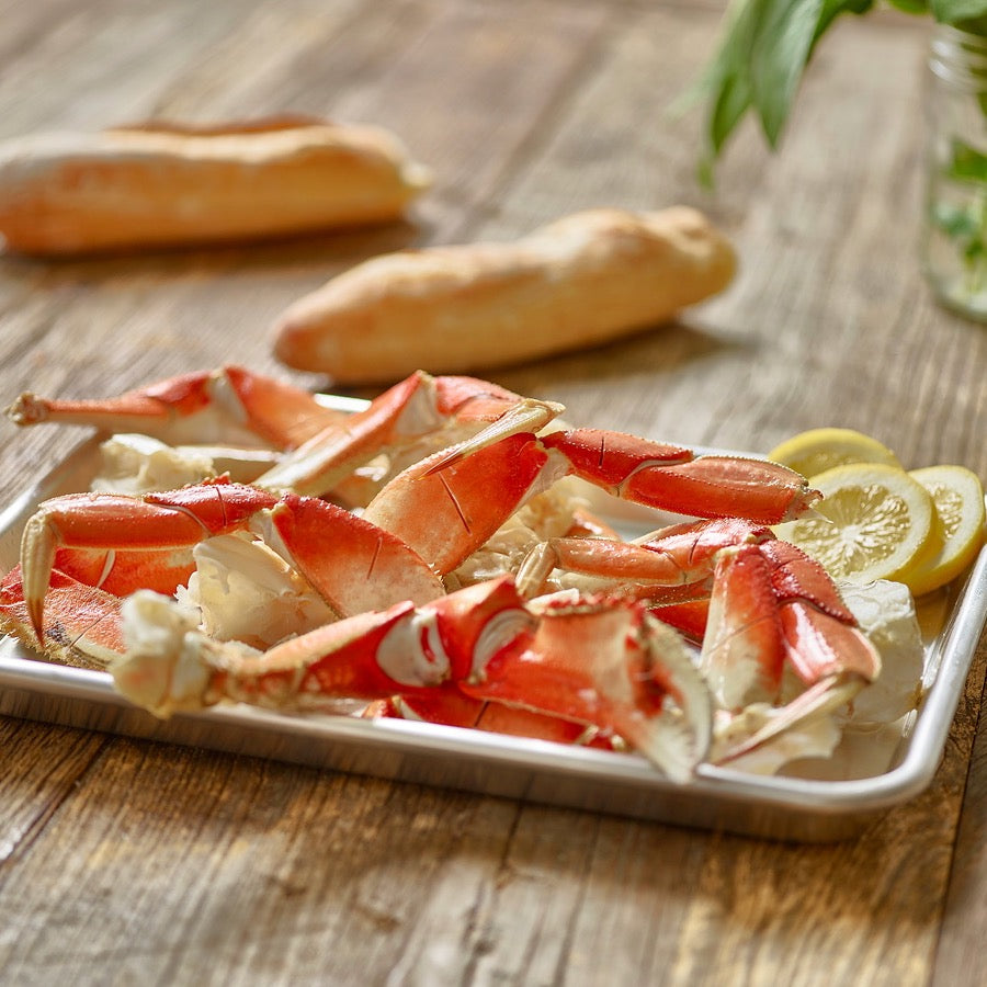 Wild Alaskan Dungeness crab legs served on a tray with lemon and bread