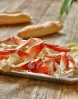 Wild Alaskan Dungeness crab legs served on a tray with lemon and bread