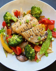 Miso marinate black cod served on a plate with assorted peppers, mushrooms, and other vegetables