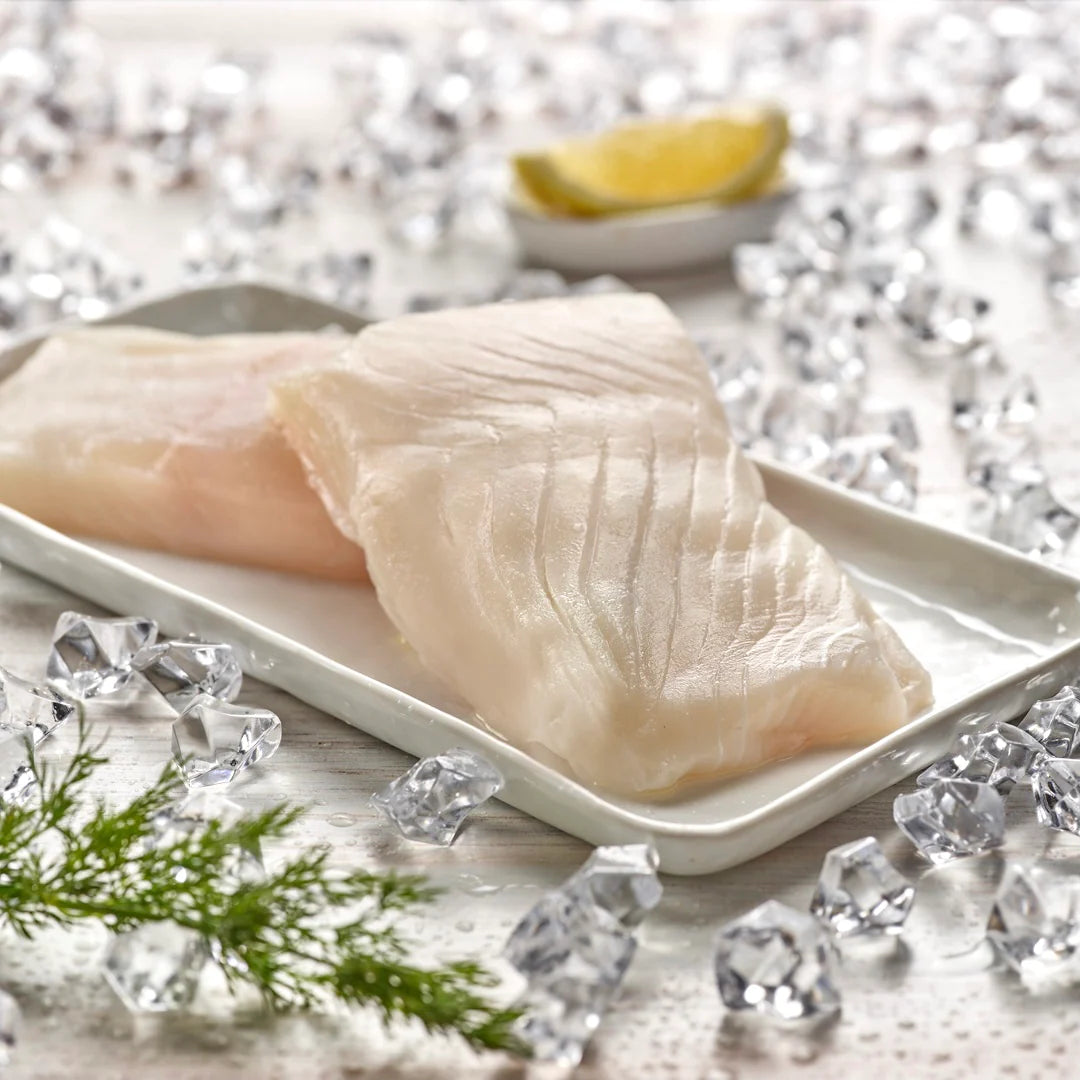 Raw halibut on a white tray with ice