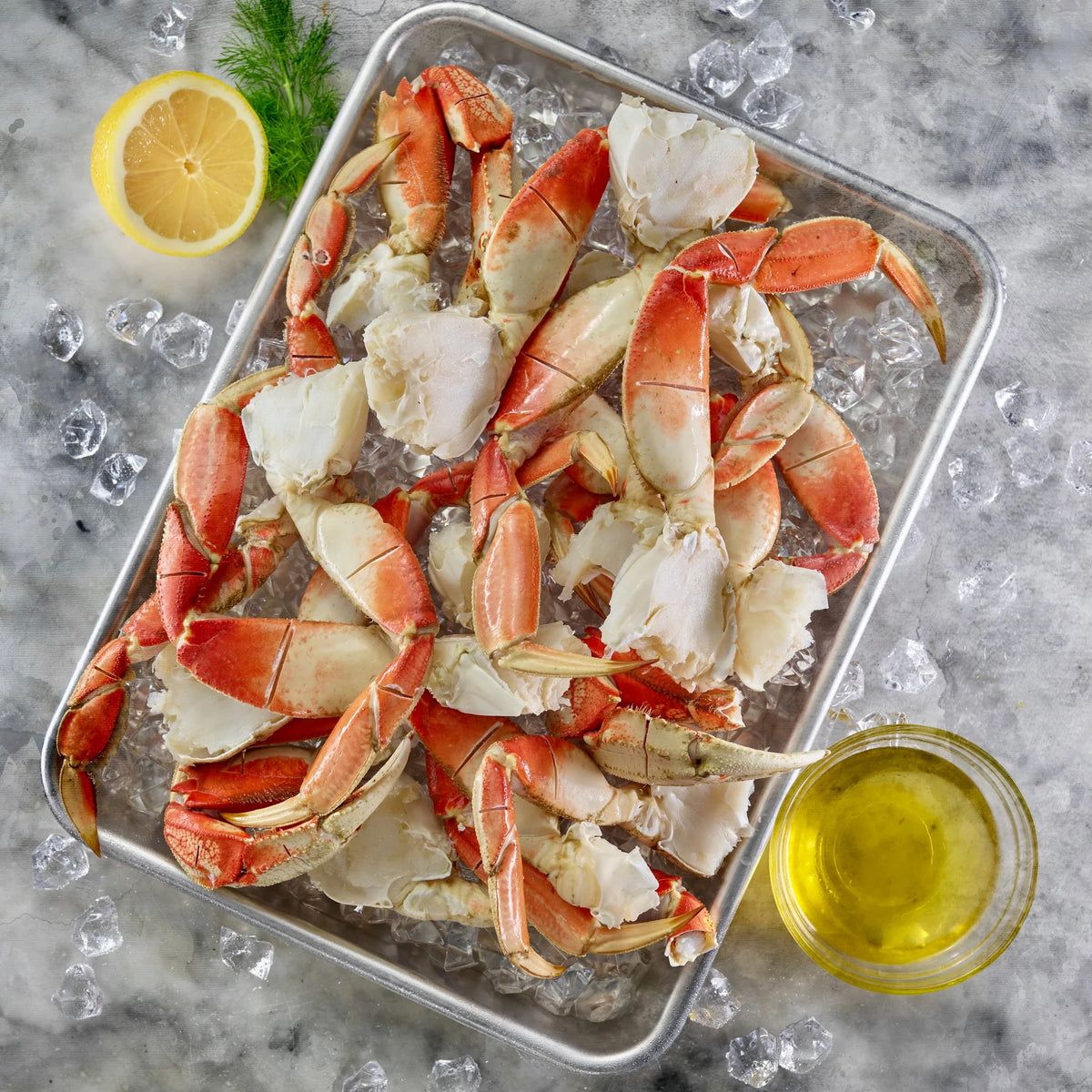 Dungeness crab leg clusters scored and separated into individual easy to crack legs.